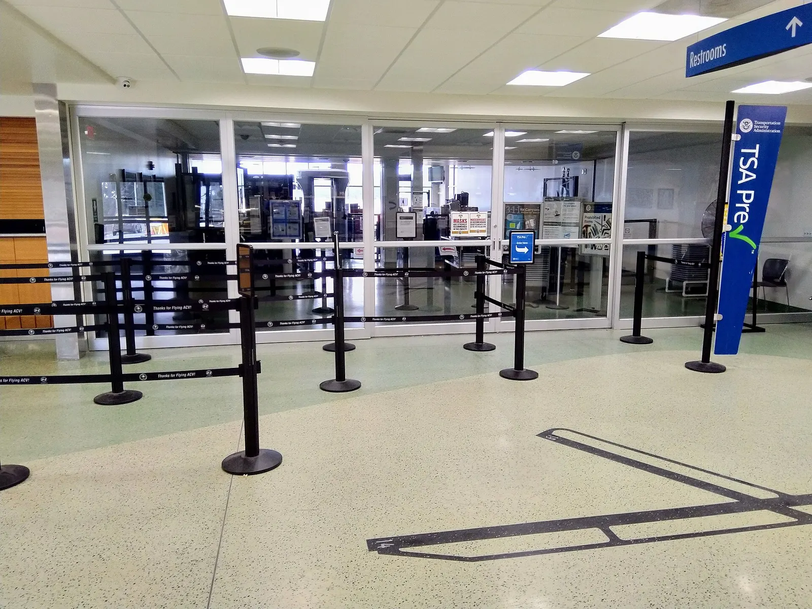 TSA checkpoint and closed gate-area door inside the ACV passenger hall.