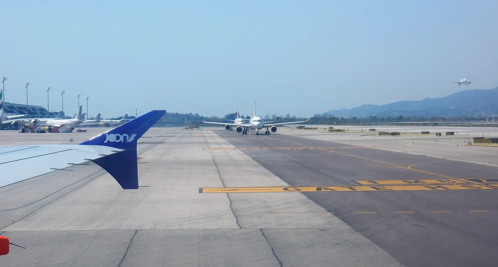 As our flight makes its way to the gate upon arrival at Barcelona's airport, several aircraft taxi to the departure runways to begin their next journeys.