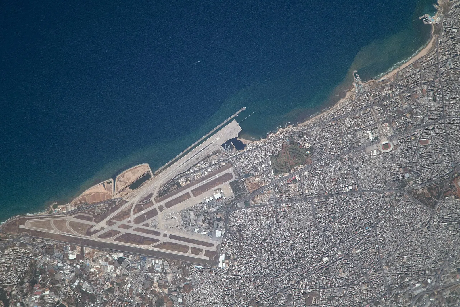 ISS aerial of Beirut-Rafic Hariri International Airport on the Mediterranean coast, showing the three-runway coastal campus and the single passenger terminal