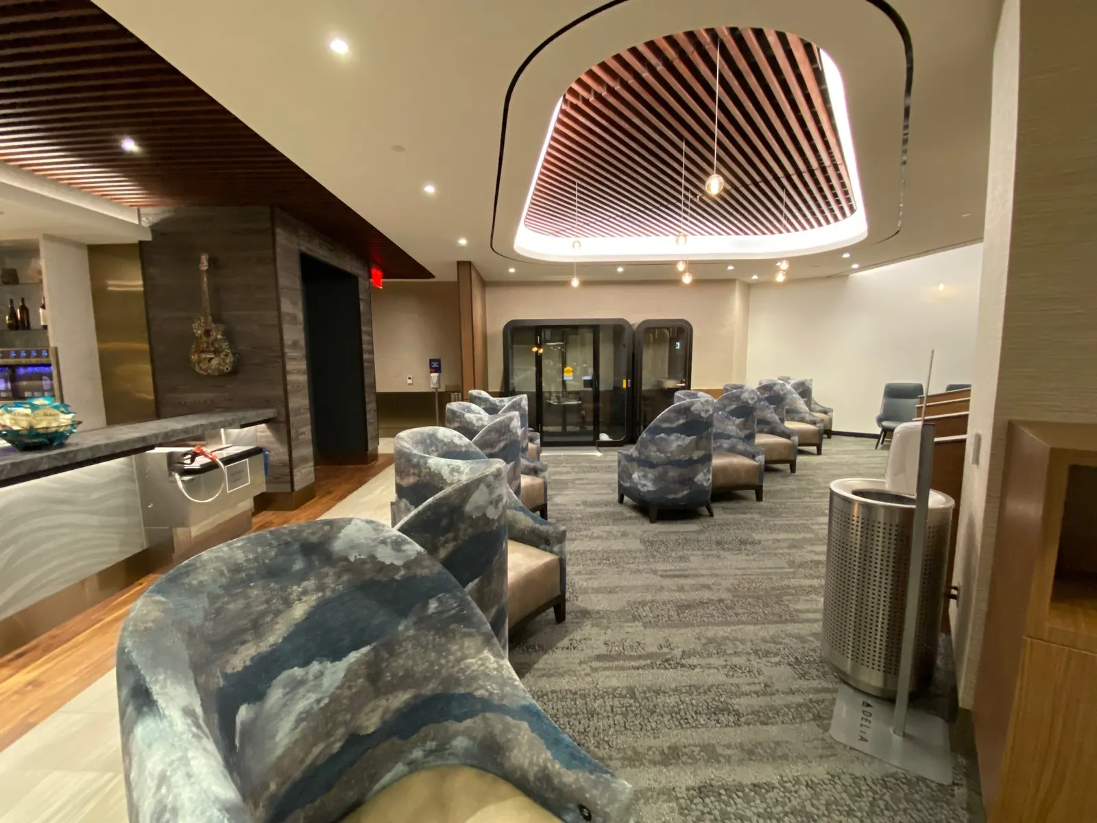 Marble-pattern chairs and guitar-pick chandelier with guitar wall sculpture in the Delta Sky Club at Nashville (BNA).