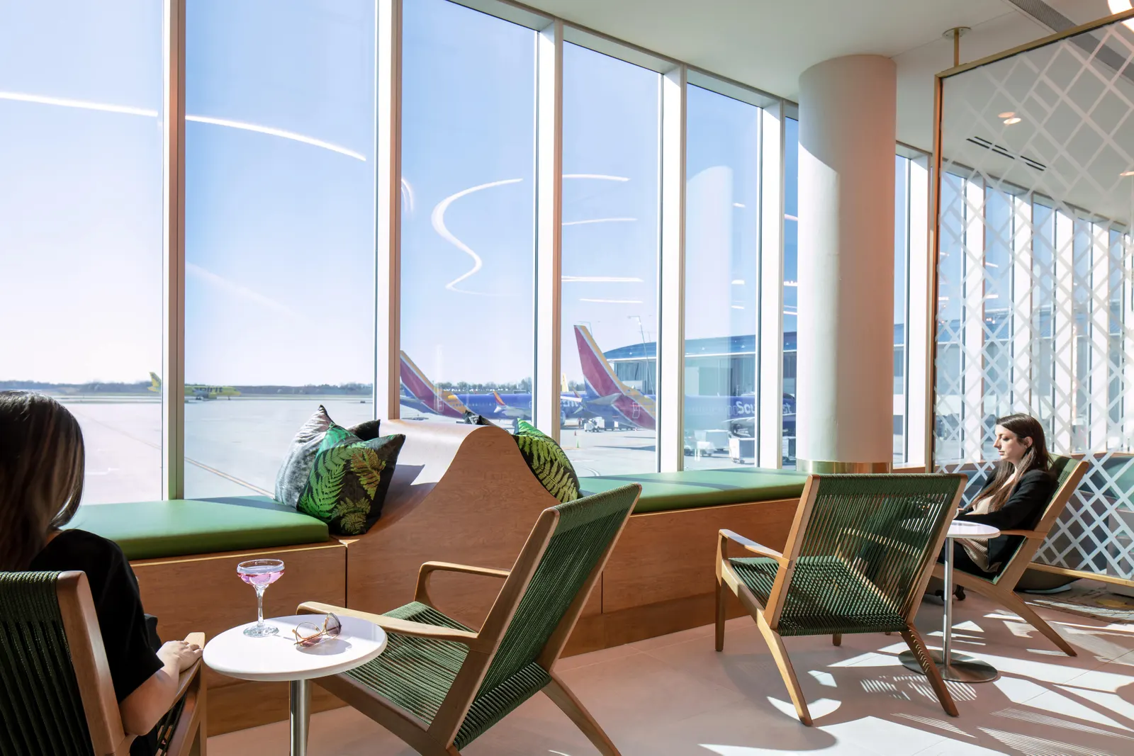 Window seating with terminal views in The Club at Charlotte Douglas (CLT).