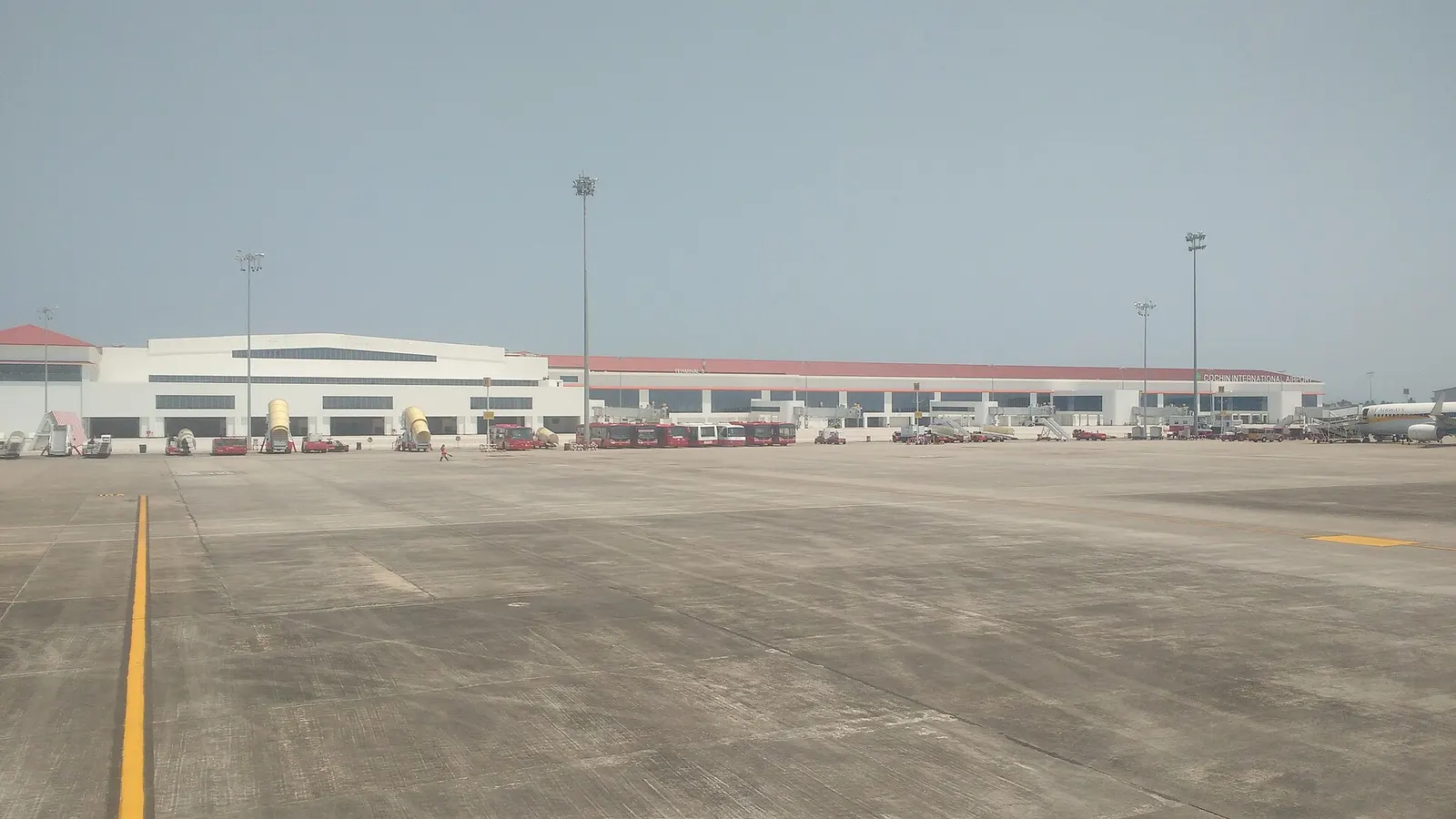 Cochin International Airport Terminal 3 airside facade with red Kerala-style roof and CIAL lettering