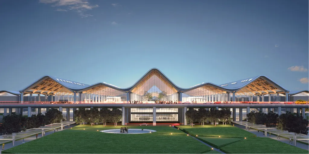 Dusk exterior of Clark International Airport’s New Terminal Building with its mountain-wave roof and lit glass facade.