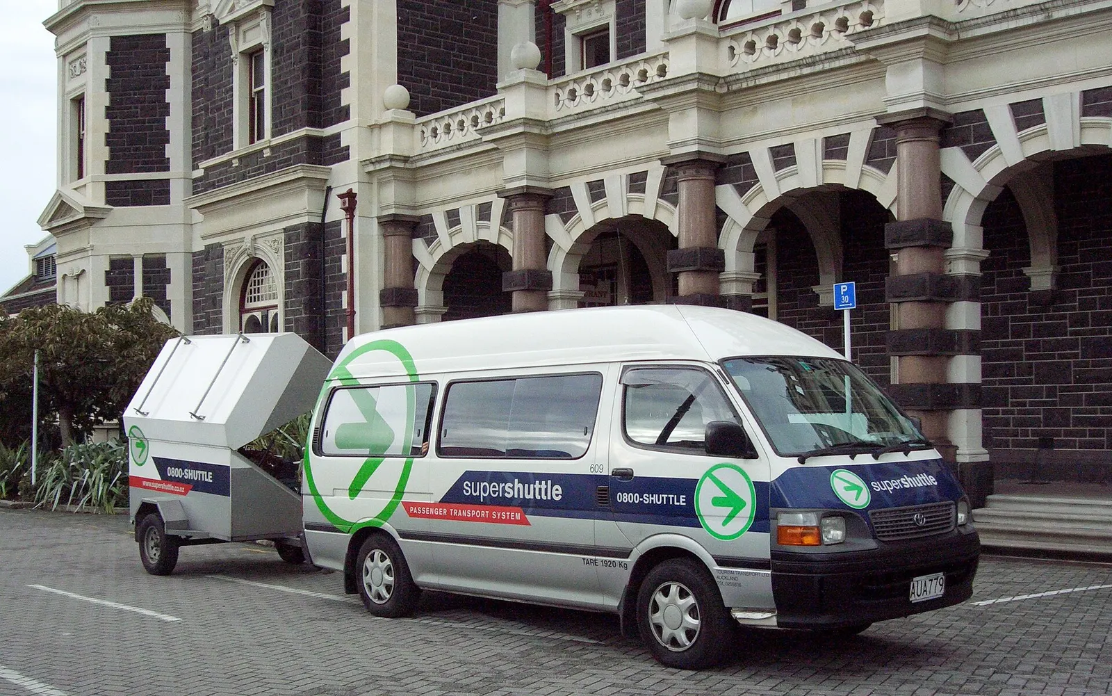Super Shuttle van operated by Tourism Transport providing shared taxi service to Dunedin Airport from Dunedin Railway Station forecourt.