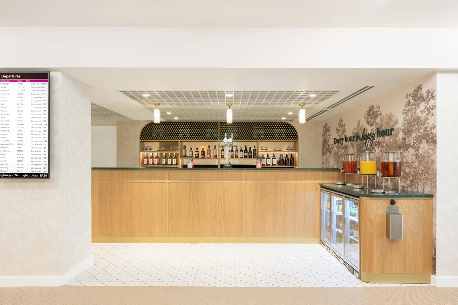 Wood-fronted bar with juice dispensers and botanical wallpaper in the Escape Lounge at Edinburgh Airport (EDI).