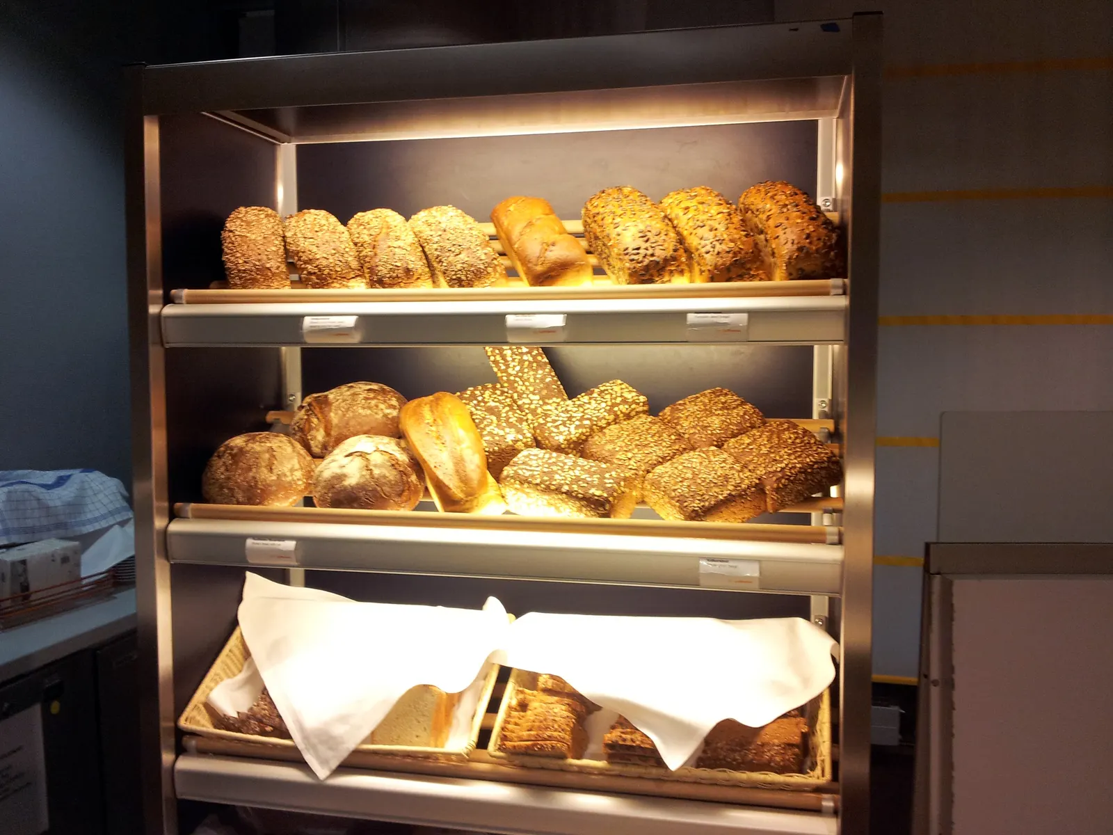 Three-tier bread display with seeded loaves and sliced baskets inside the Lufthansa Senator Lounge at Frankfurt Airport (FRA).