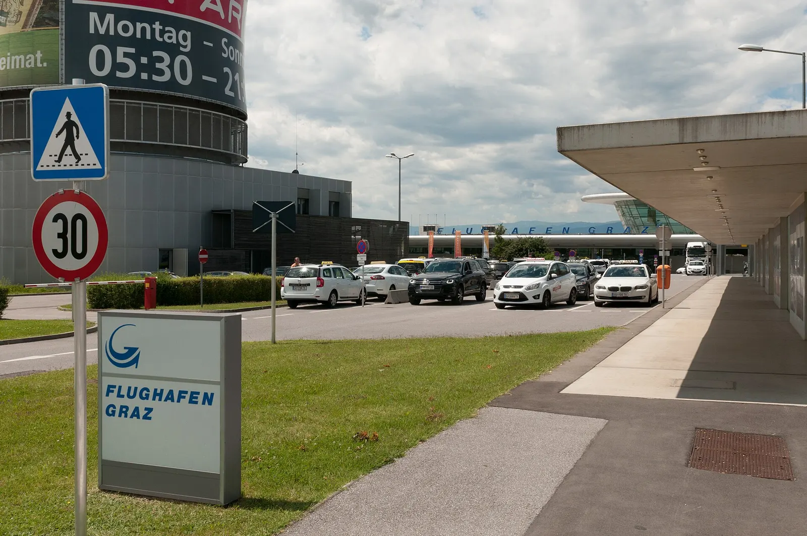 Landside Flughafen Graz sign and taxi curb in front of the passenger terminal