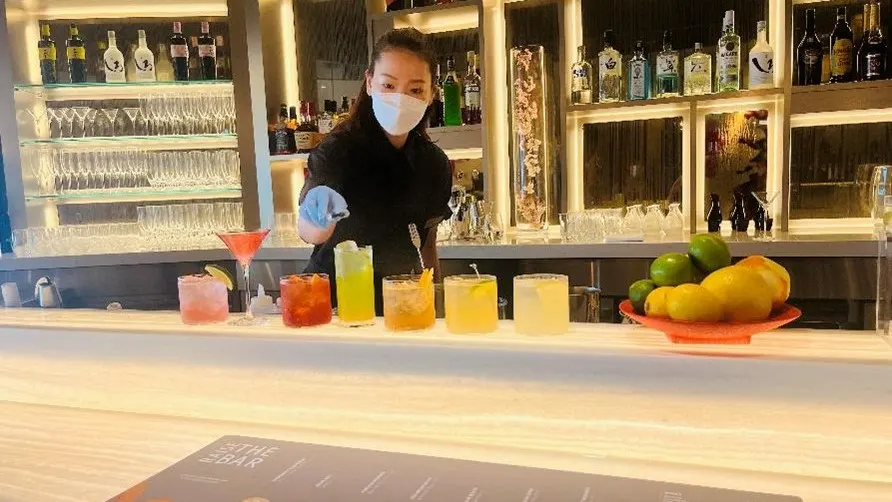 Premium bar in the Delta Sky Club at Haneda Airport with bottles and seating.