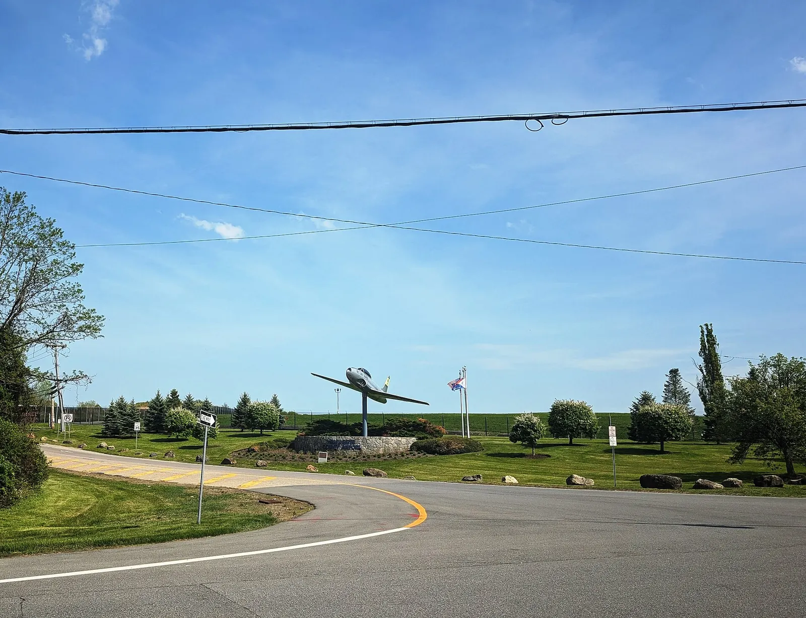 May 2025 roadside entrance to Westchester County Airport from NY 120 at Airport Road, looking toward the civil terminal — not LGA and not Stewart.