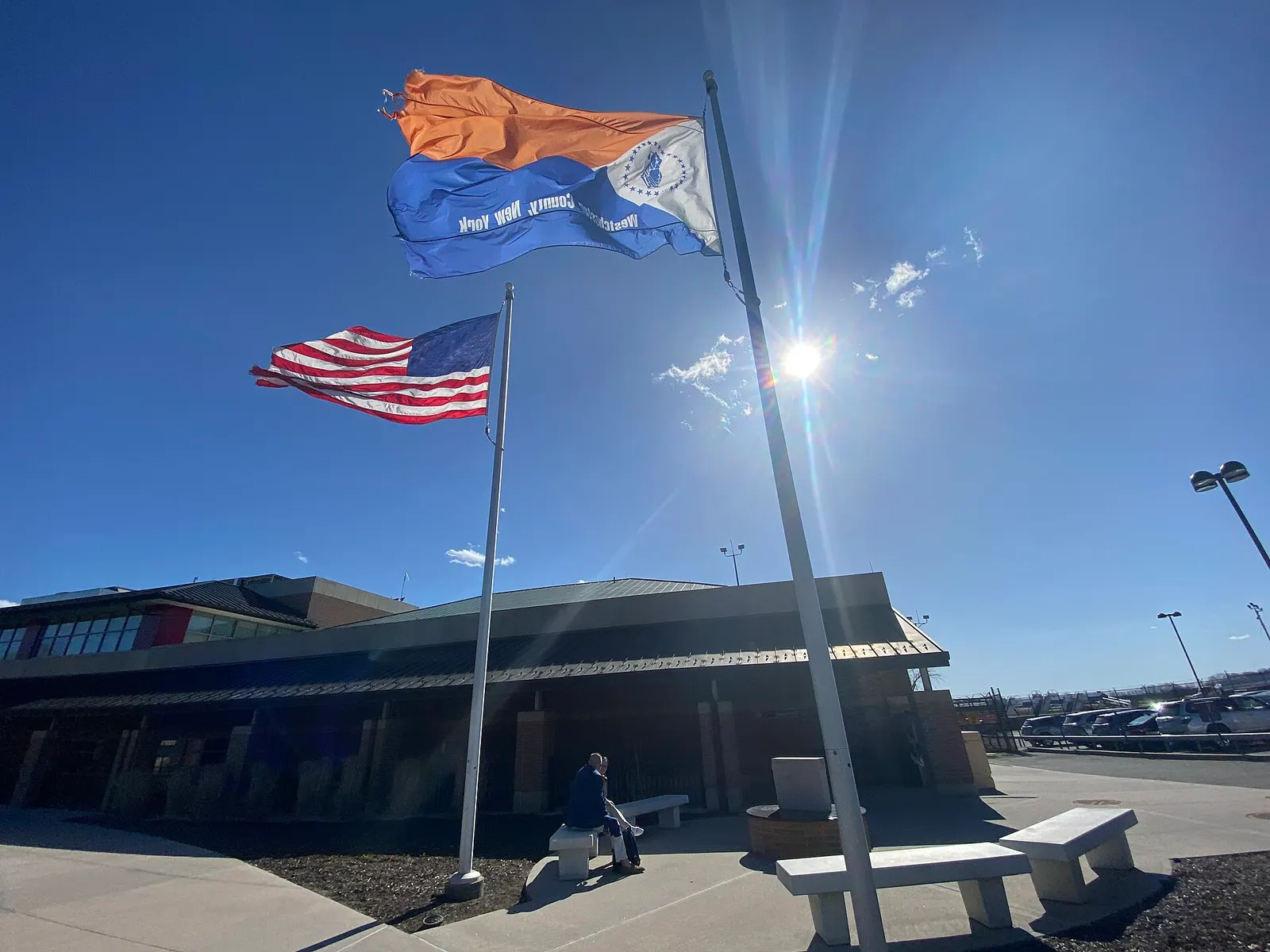 April 2022 U.S. and Westchester County flags in front of the civil passenger terminal at Westchester County Airport.