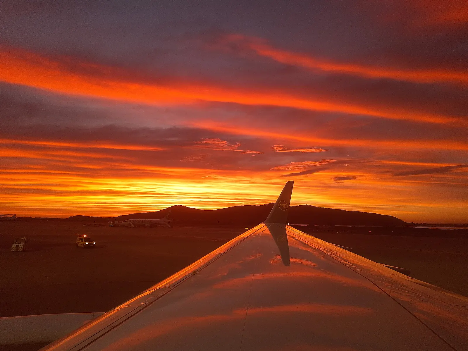 Red clouds above Ibiza airport, reflected in the plane's wing