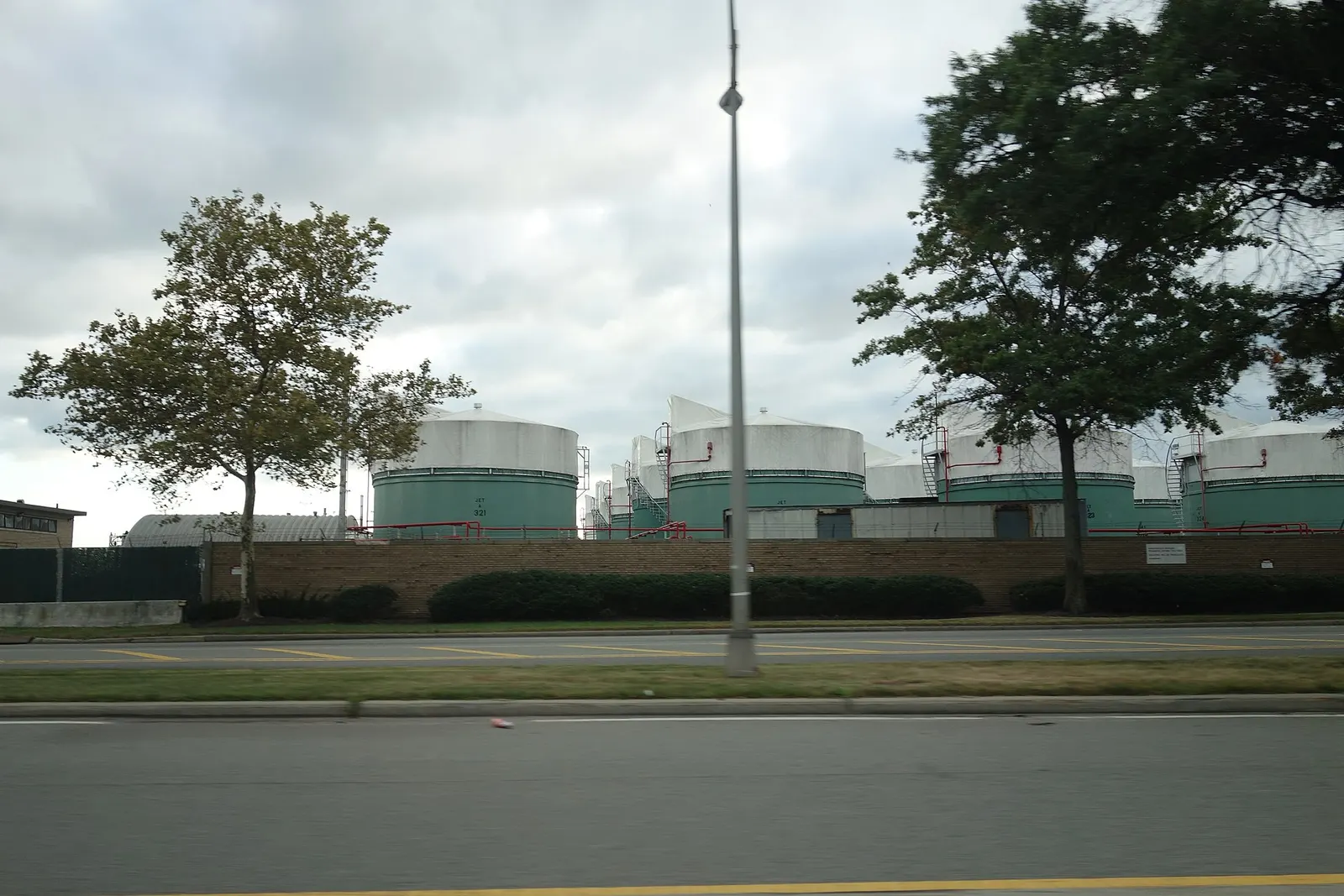 Traveling southeast on the Van Wyck Expressway towards the terminals of John F. Kennedy International Airport, near South Ozone Park, Queens. Pictured is the fuel farm along the south edge of the airport.