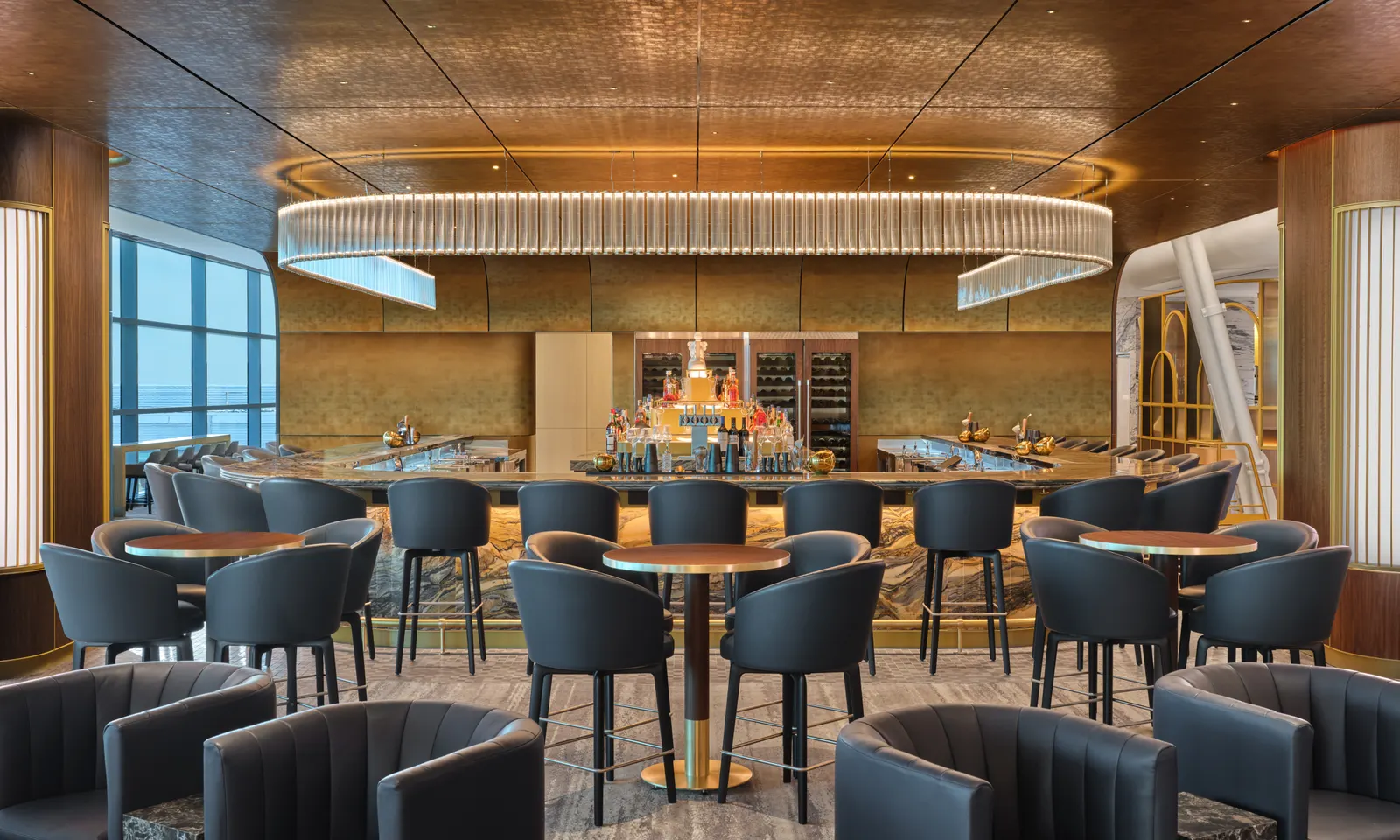 Art Deco-inspired lighting fixture over the premium bar with charcoal seating and airfield windows in the Delta One Lounge at New York JFK Terminal 4.