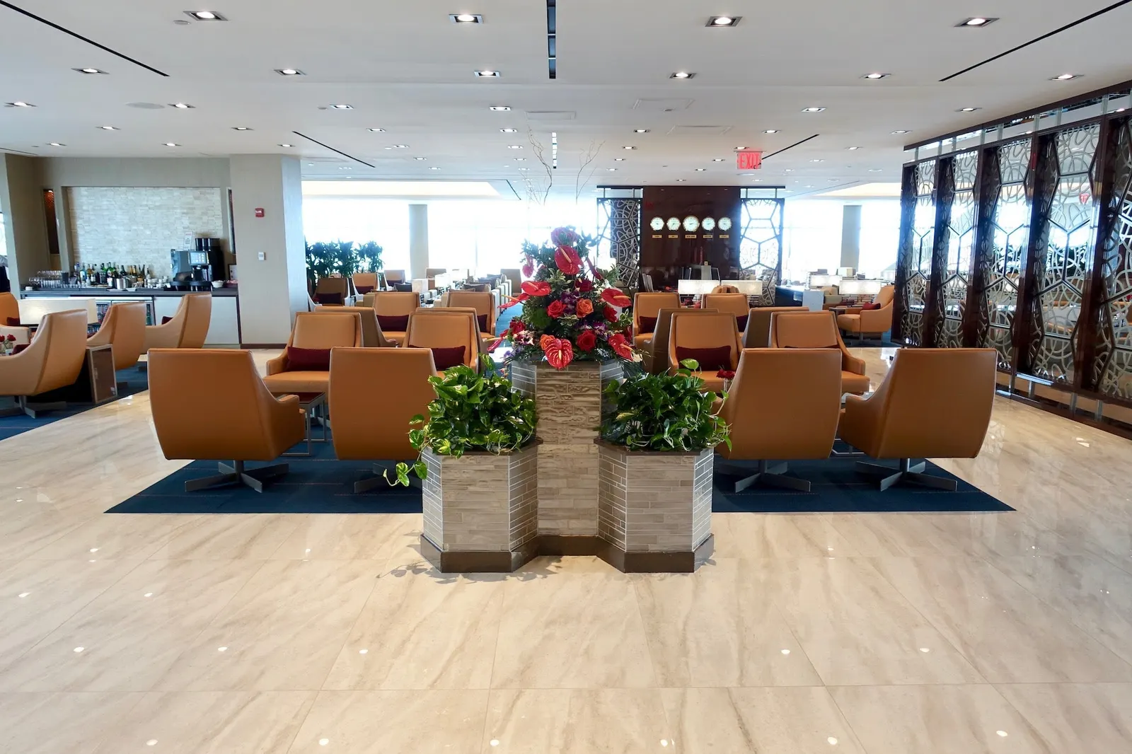 Lounge seating facing windows in the Emirates Lounge at New York JFK Terminal 4.