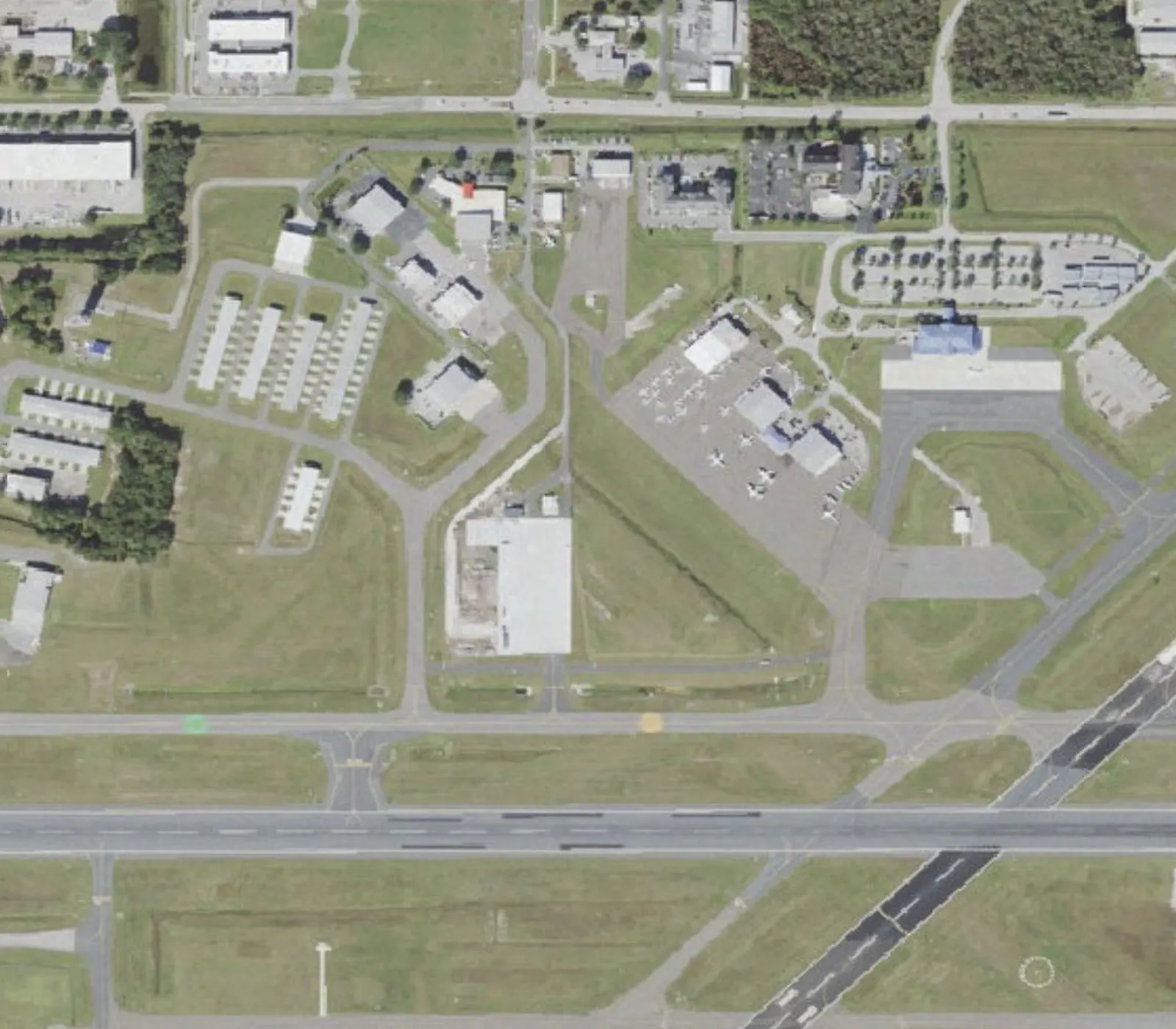 Closer aerial of the LAL passenger terminal, paved parking lot, and overflow grass lot on Don Emerson Drive.