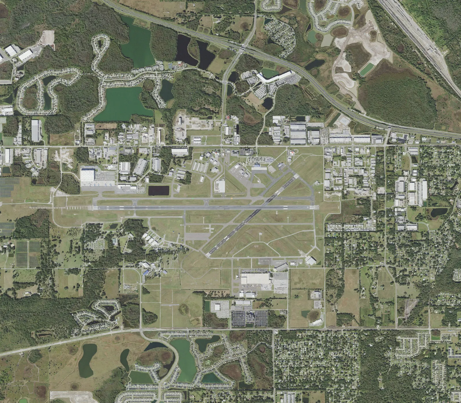 Overhead aerial of Lakeland Linder International Airport showing runway 10/28, the north-side passenger terminal, and the Don Emerson parking lots.