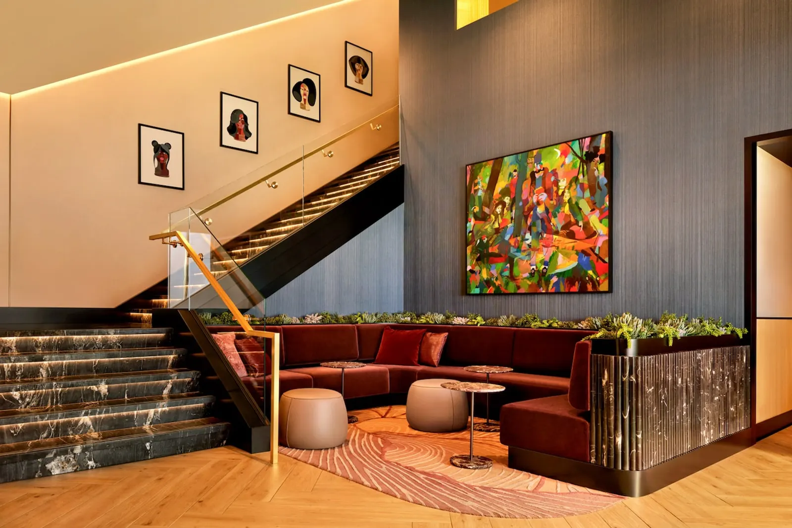Jewel-tone velvet chairs and staircase with curated artwork in the Chase Sapphire Lounge at Las Vegas (LAS).