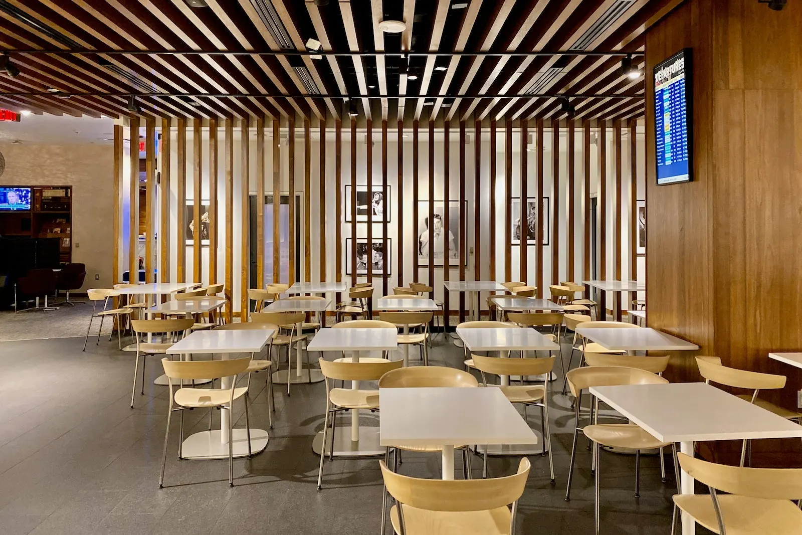 Cafe-style dining tables behind wood-slat screens in The Centurion Lounge at Las Vegas Harry Reid (LAS).