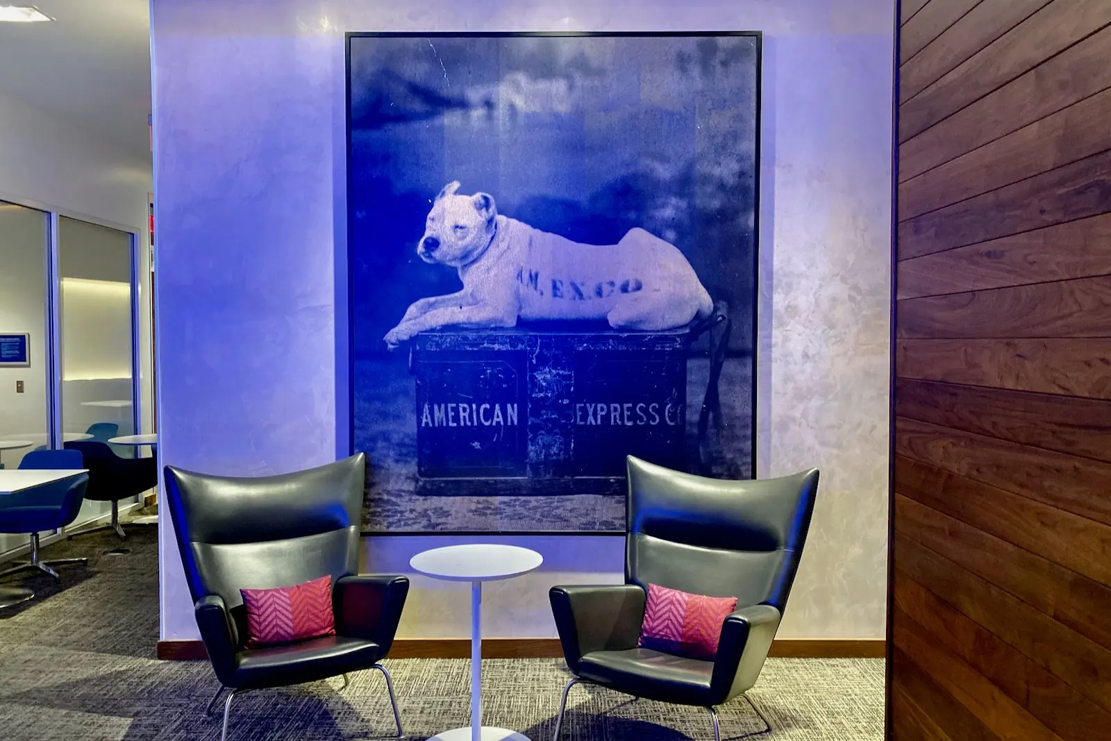 Black wingback chairs beside Amex travel artwork in The Centurion Lounge at Las Vegas Harry Reid (LAS).