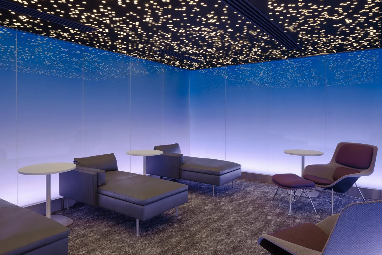 Moonrise tranquility room with starry-night ceiling, blue backlit walls and chaise lounges in the Centurion Lounge at LAX.