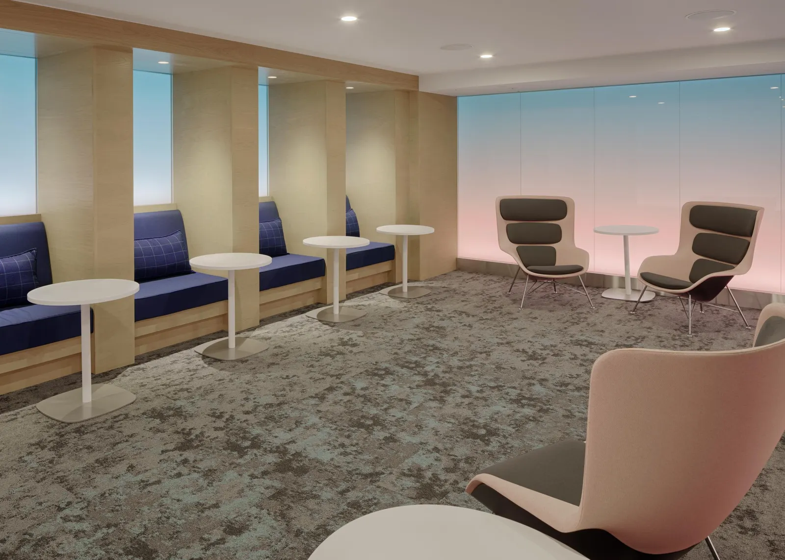Sunrise tranquility room with blue-to-pink backlit wall panels, wood alcove booths and beige armchairs in the Centurion Lounge at LAX.