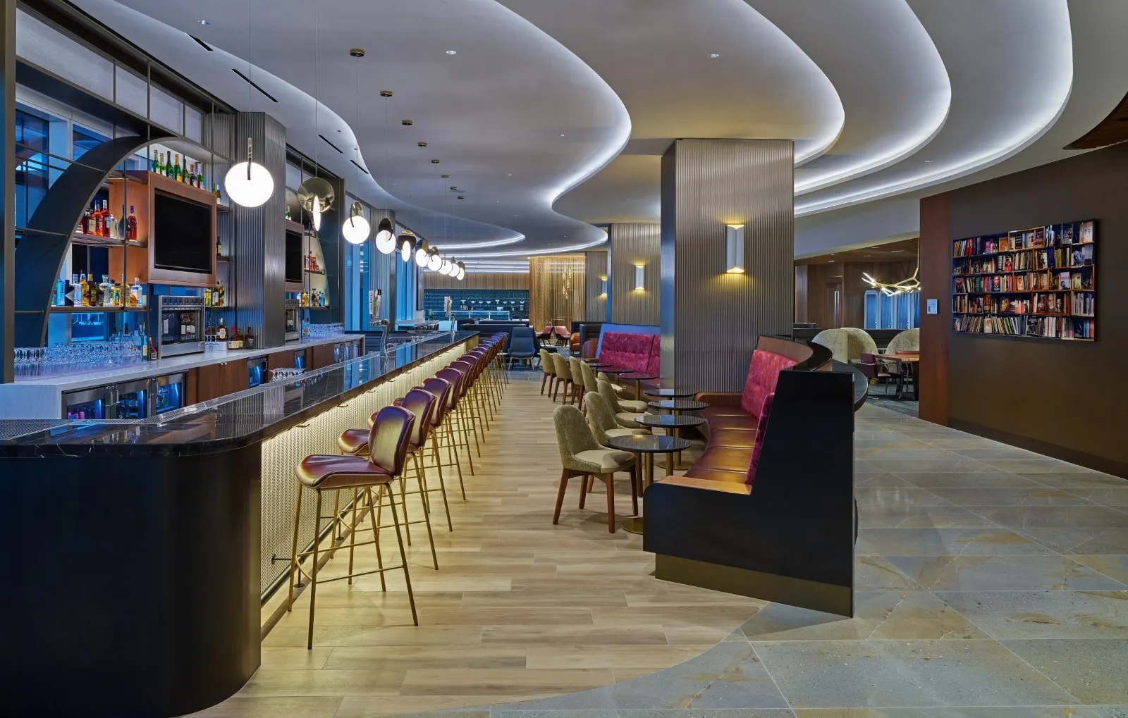 Long bar with spherical pendants under a wave ceiling in the Delta Sky Club at LAX Terminal 3.