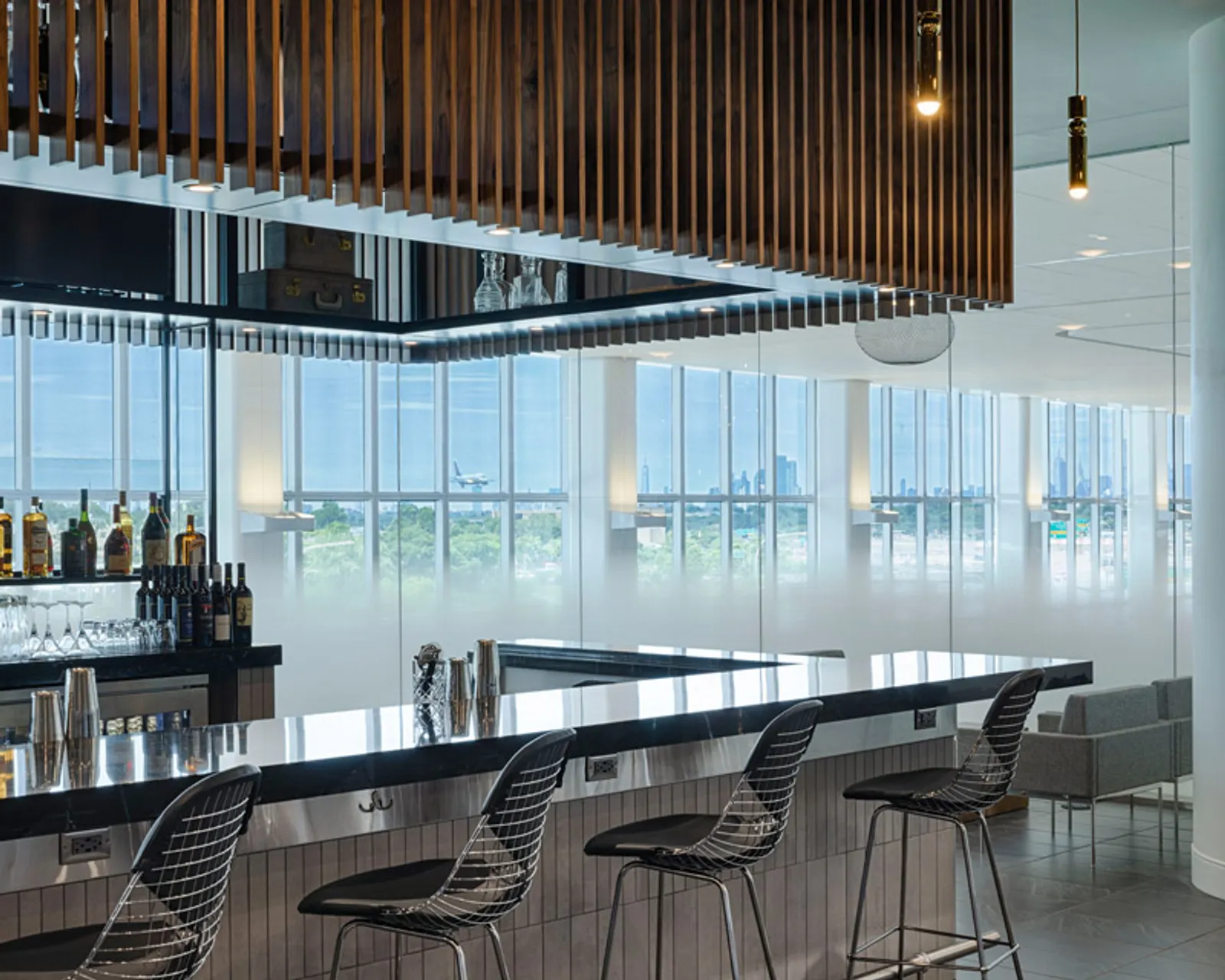 Bar area with city views in The Centurion Lounge at LaGuardia Airport (LGA).