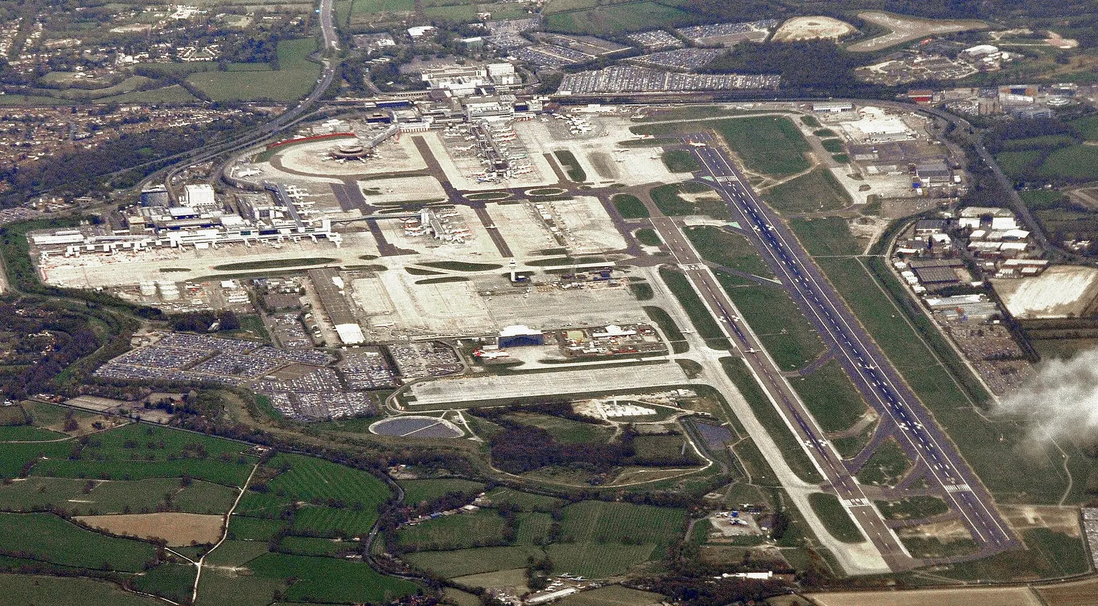 Aerial view of London Gatwick Airport with the main runway, terminal roofs and apron