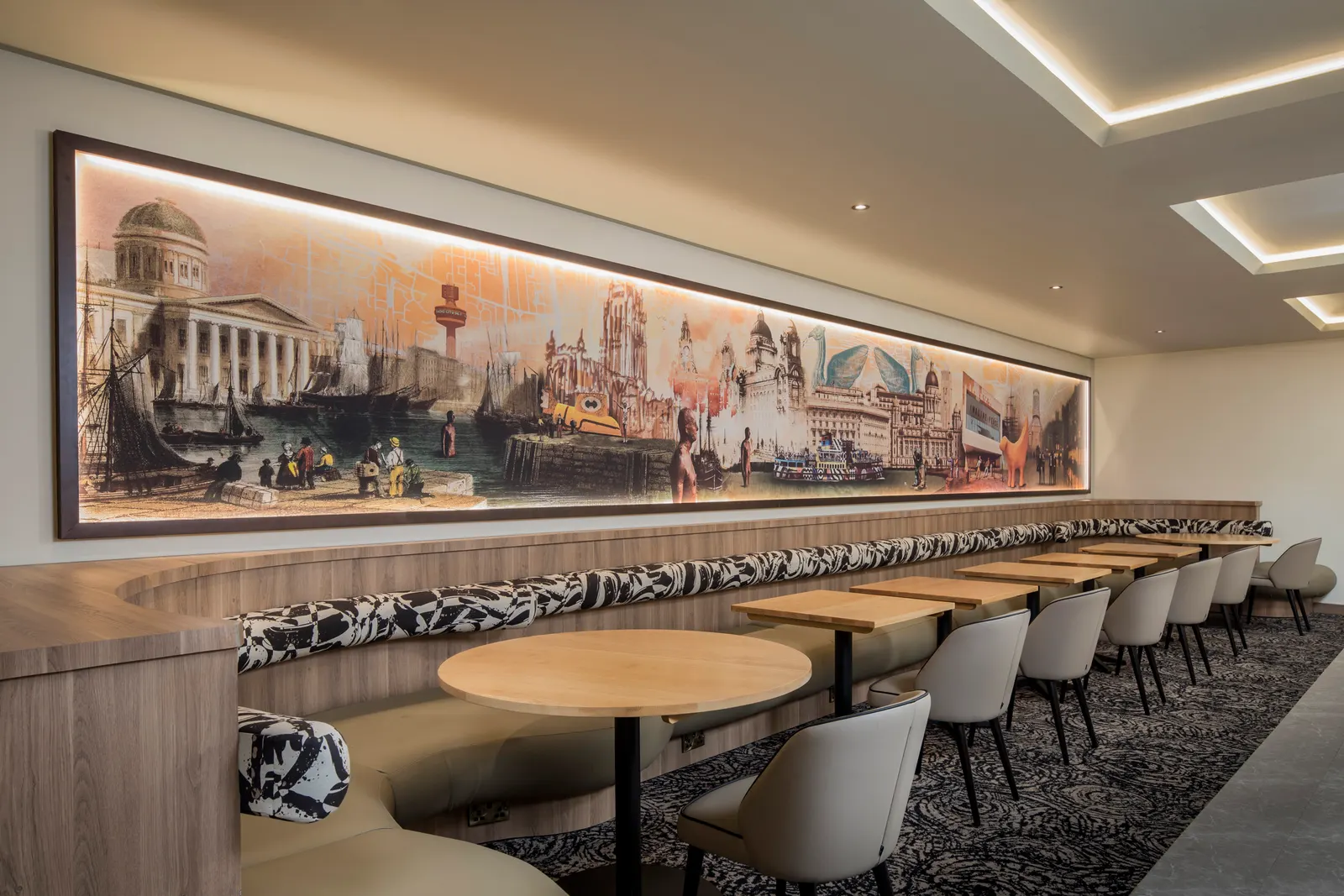 Seating beneath the Liverpool skyline mural in the Aspire Lounge at Liverpool John Lennon Airport (LPL).