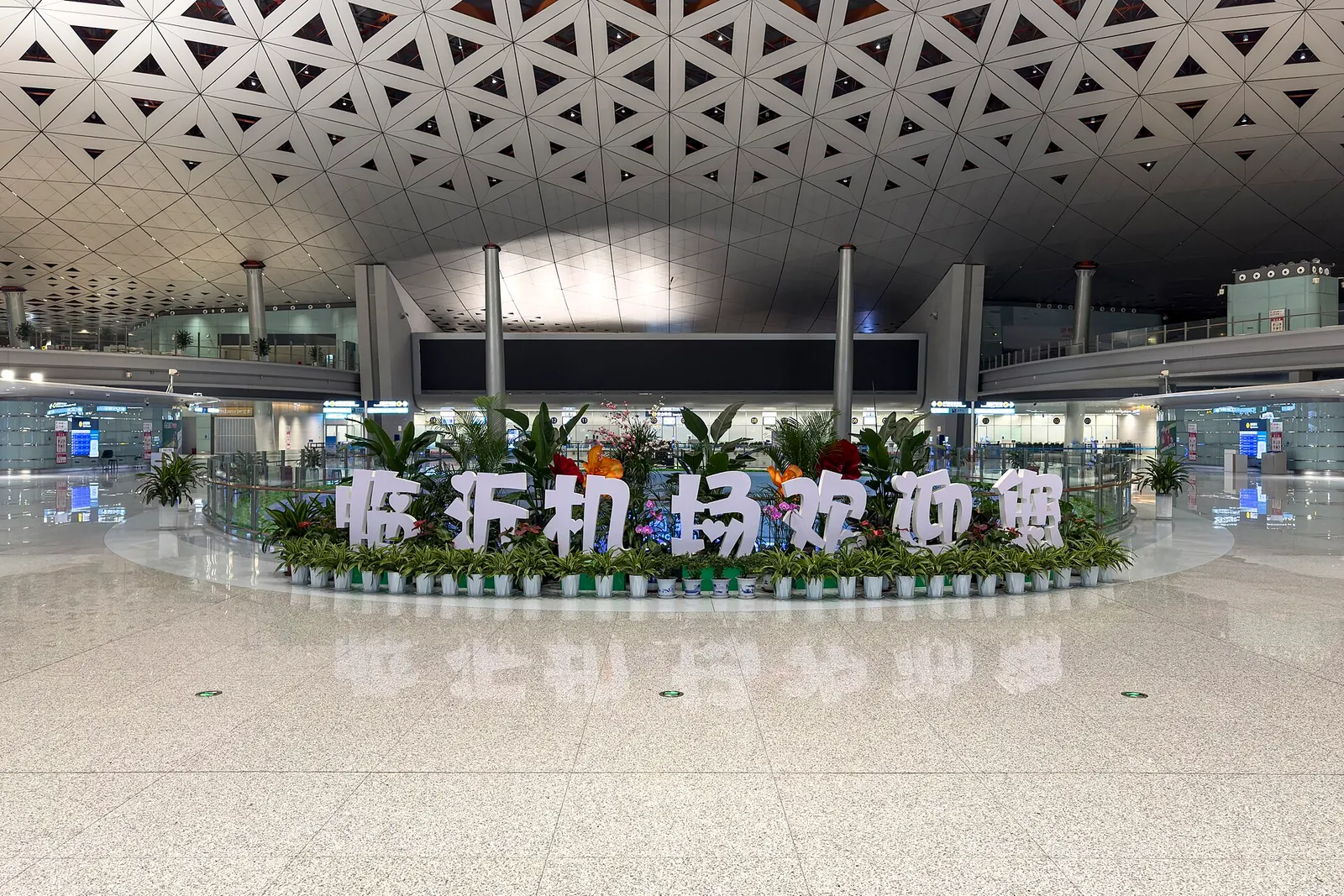 T2 domestic departures hall at Linyi Qiyang on 1 May 2026, looking across the 2F check-in floor.