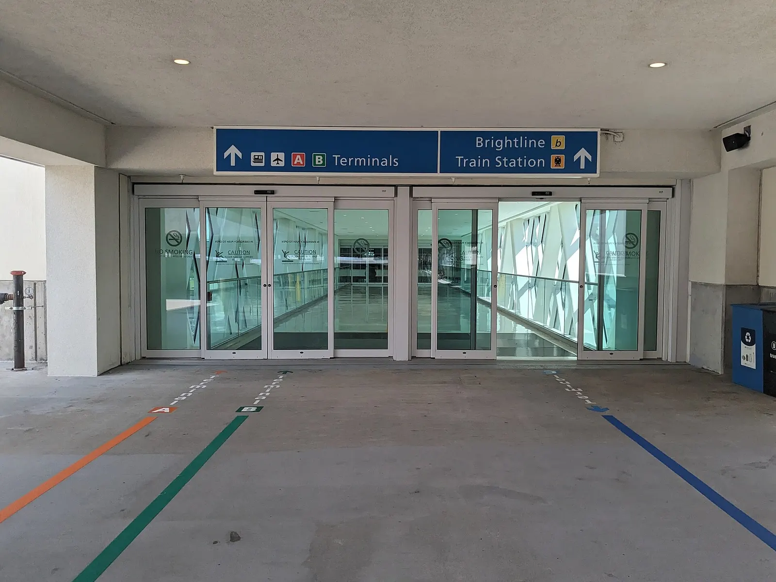 Entrance to the airport from the parking garage, showing wayfinding for terminals A & B, as well as Brightline, which is double listed as Train Station and Brightline