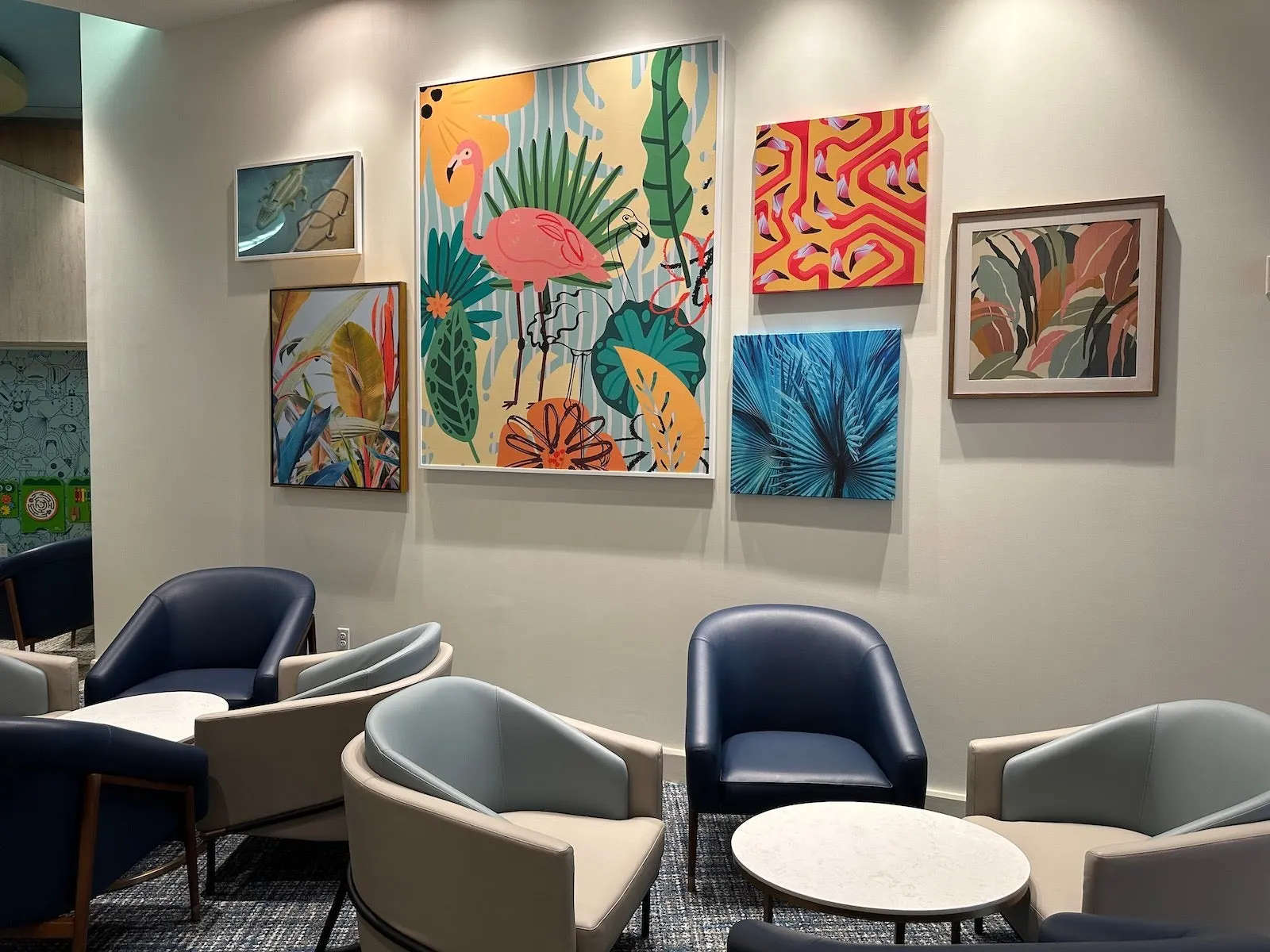 Family seating beside tropical flamingo artwork wall in Plaza Premium Lounge at Orlando Terminal C (MCO).