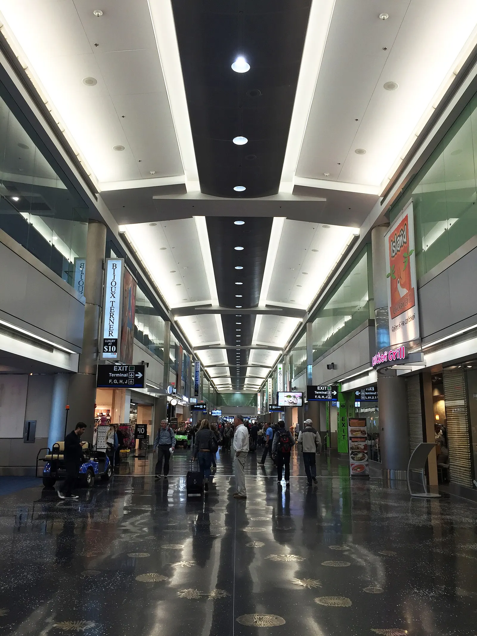 Looking down the length of Concourse D at Miami International Airport with gate seating and jet bridges.