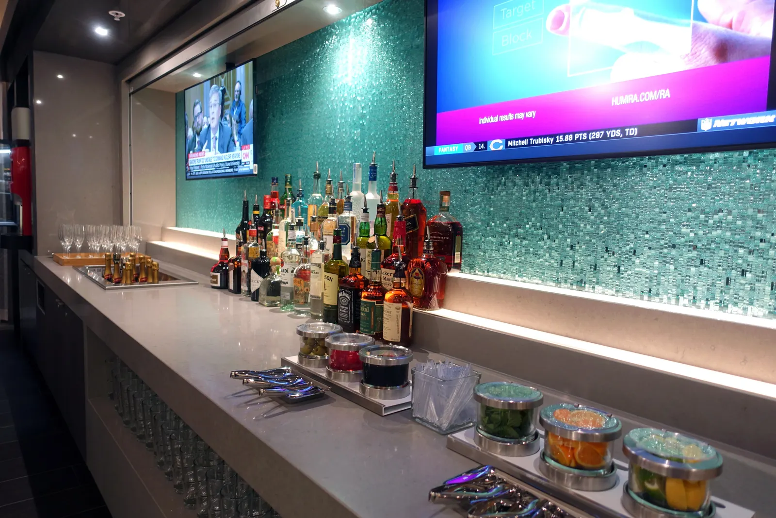 Self-serve bar with teal tile backsplash in the American Airlines Flagship Lounge at Miami (MIA).