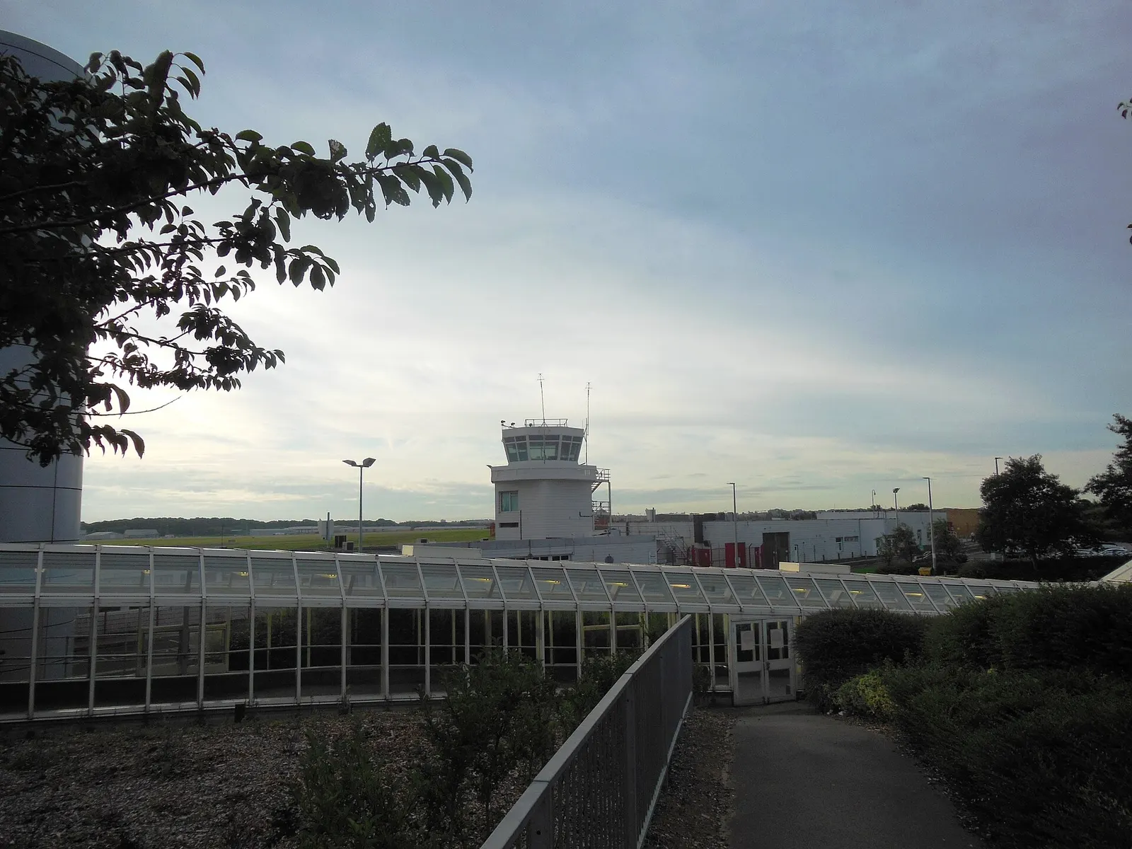 Looking south east to the old control tower, Newcastle Airport . The walkway links the airport terminal building, left, to the Airport station building on the Tyne and Wear Metro to the right.