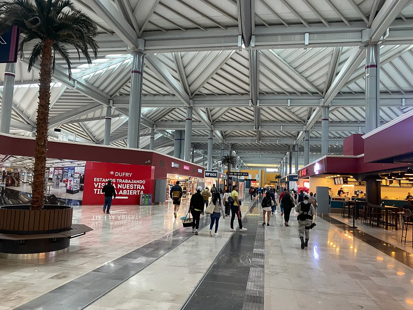 Departures commercial hall at Felipe Ángeles International Airport in 2024, with shops and the high timber ceiling.