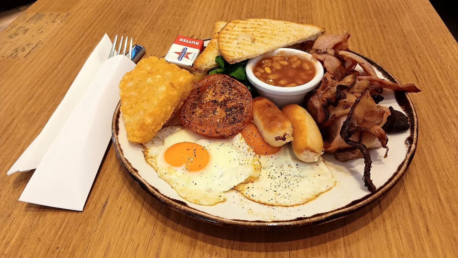 An All Day Big Breakfast, served at Coffee Quarter, Terminal 4, Perth Airport, and described as "[b]acon, tomato, pork sausages, baked beans, wilted greens, mushrooms, potato gratin, sourdough toast and topped with 2 free range eggs"