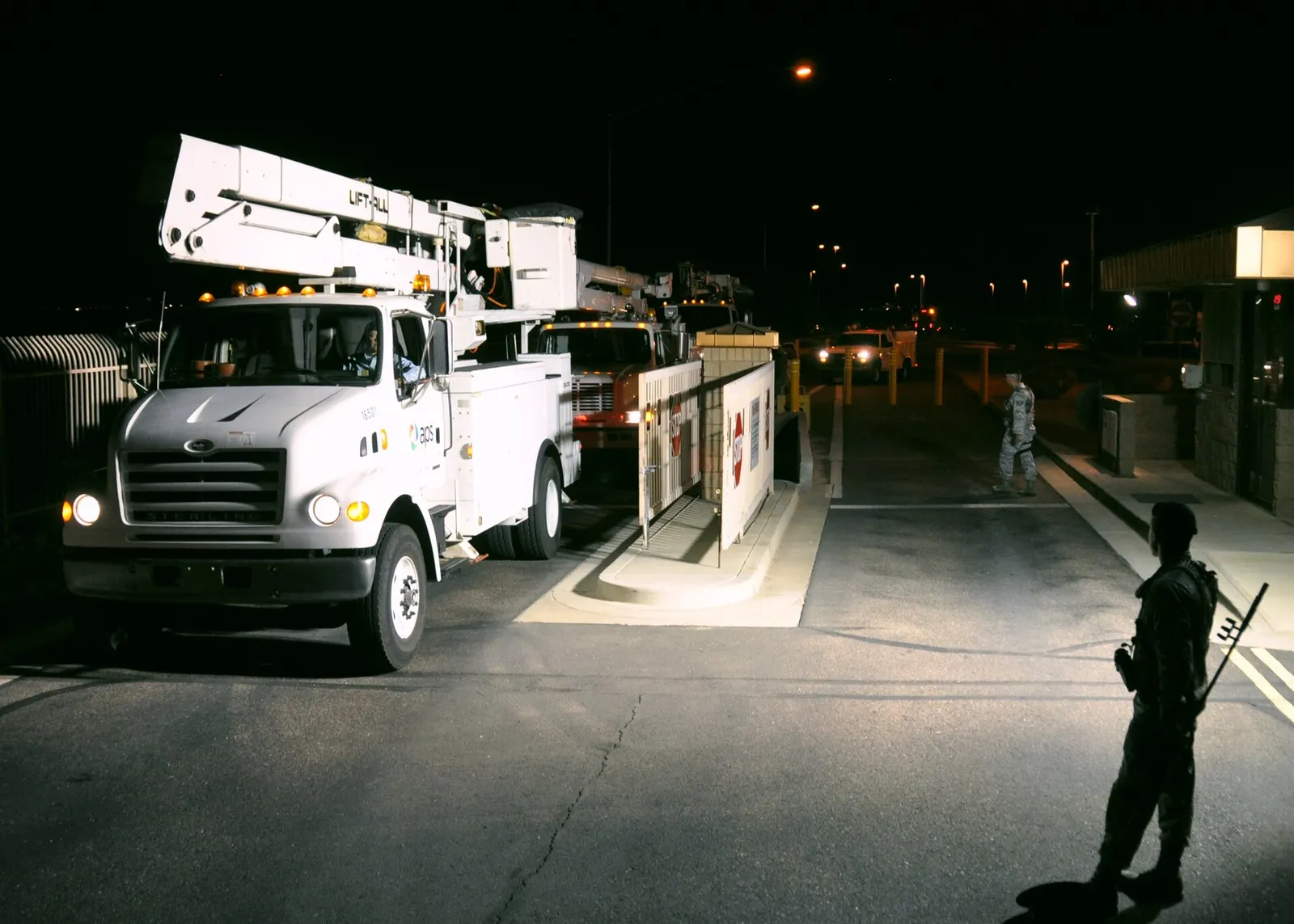 Power company utility vehicles clear the main gate checkpoint of 161st Air Refueling Wing, Arizona Air National Guard, at Sky Harbor International Airport in Phoenix, Nov. 1, 2012. Arizona utility companies are providing service equipment and personnel to assist in Hurricane Sandy recovery efforts o