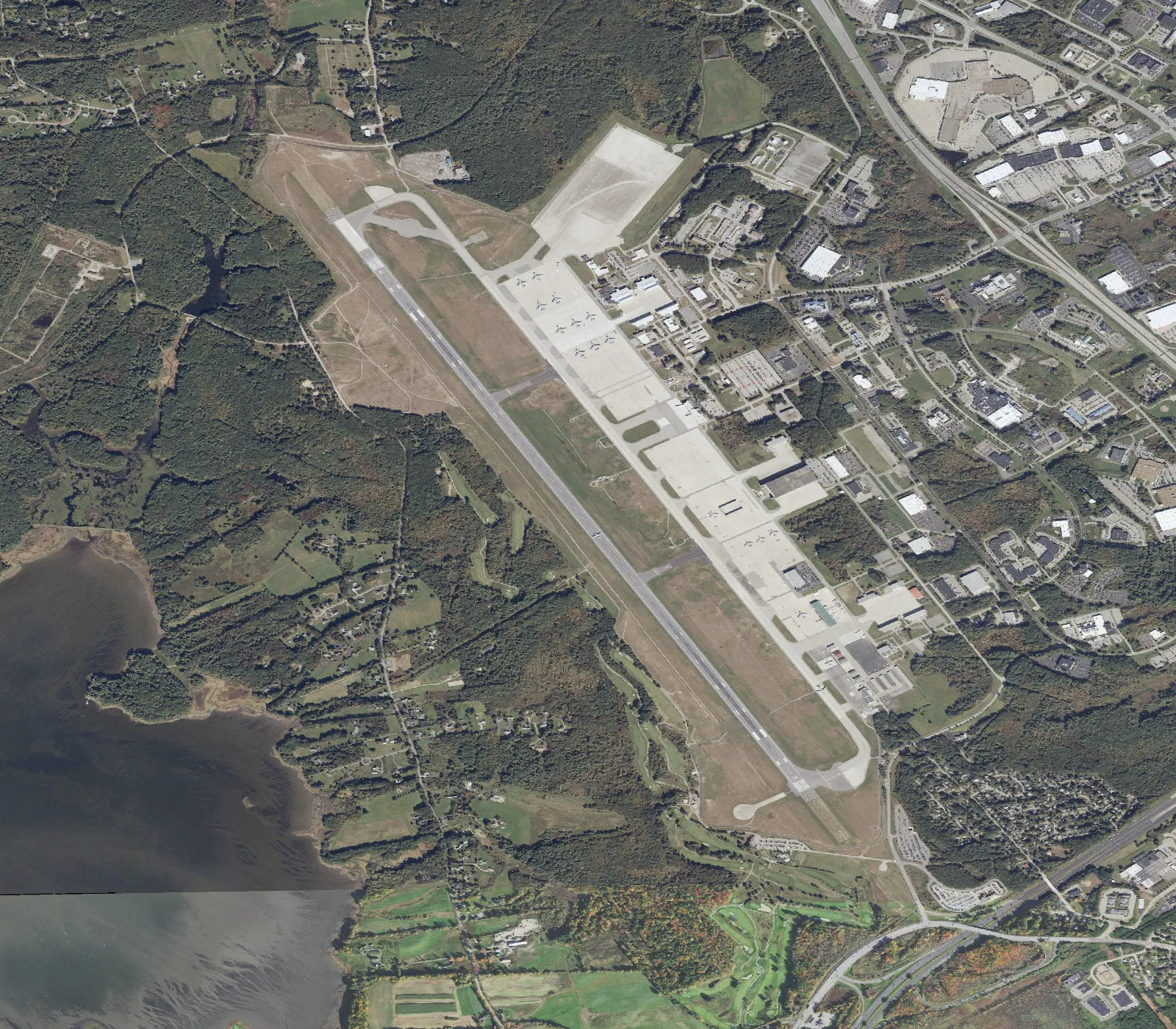 Overhead aerial of Portsmouth International Airport at Pease showing runway 16/34, the east-side Airline Avenue campus, and leftover tanker parking on the west ramp.