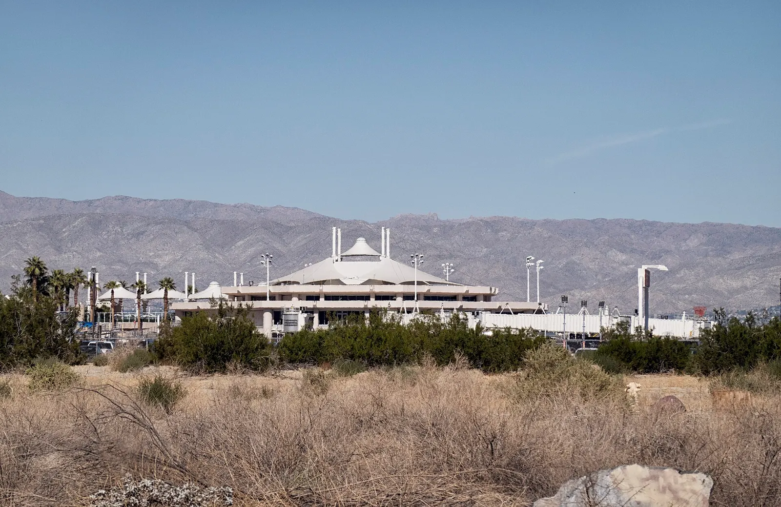 Daytime view of the Palm Springs International Airport terminal and curb from the parking side.