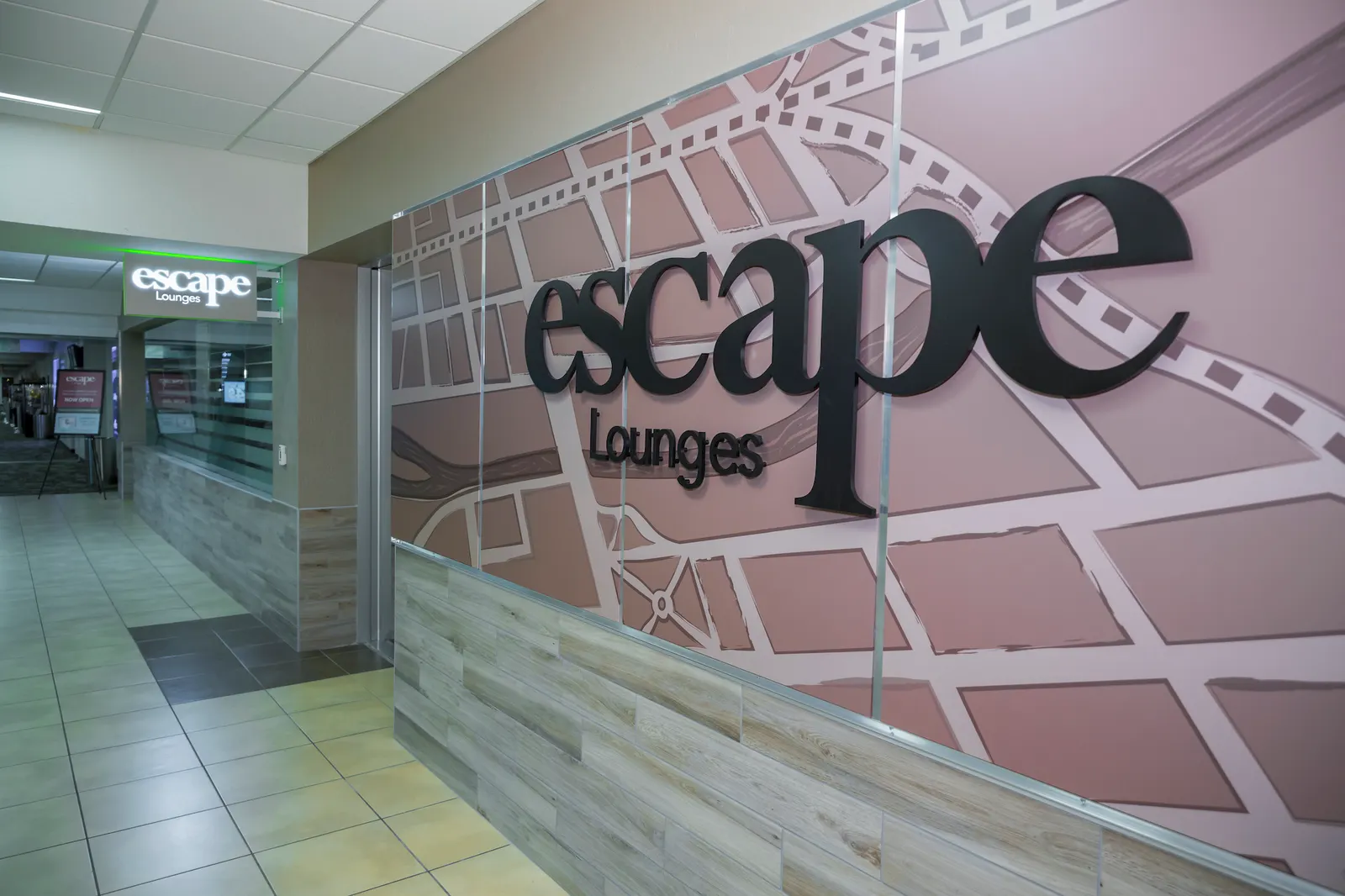 Reception desk and Escape Lounges logo wall at the Escape Lounge at Reno-Tahoe International Airport (RNO).