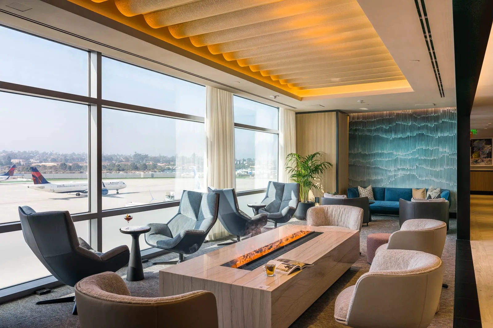 Lounge chairs with tarmac views in the Chase Sapphire Lounge by The Club at San Diego International Airport (SAN).