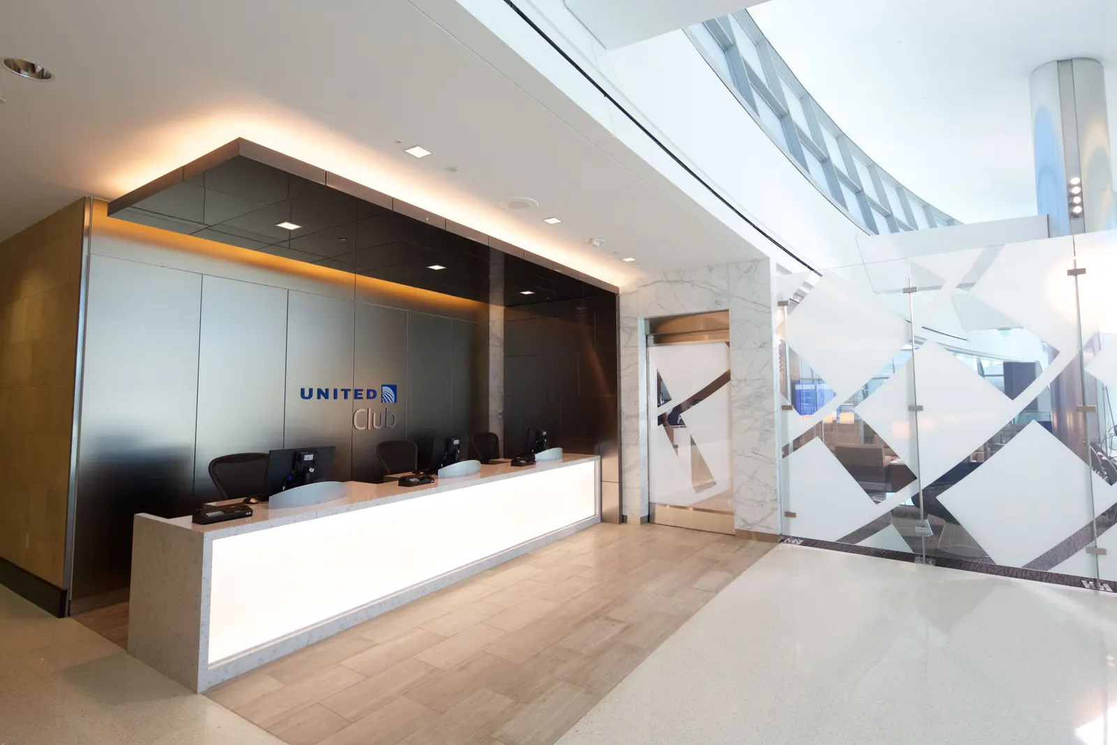 Frosted-glass reception desk under the UNITED Club logo at San Diego International Airport (SAN).