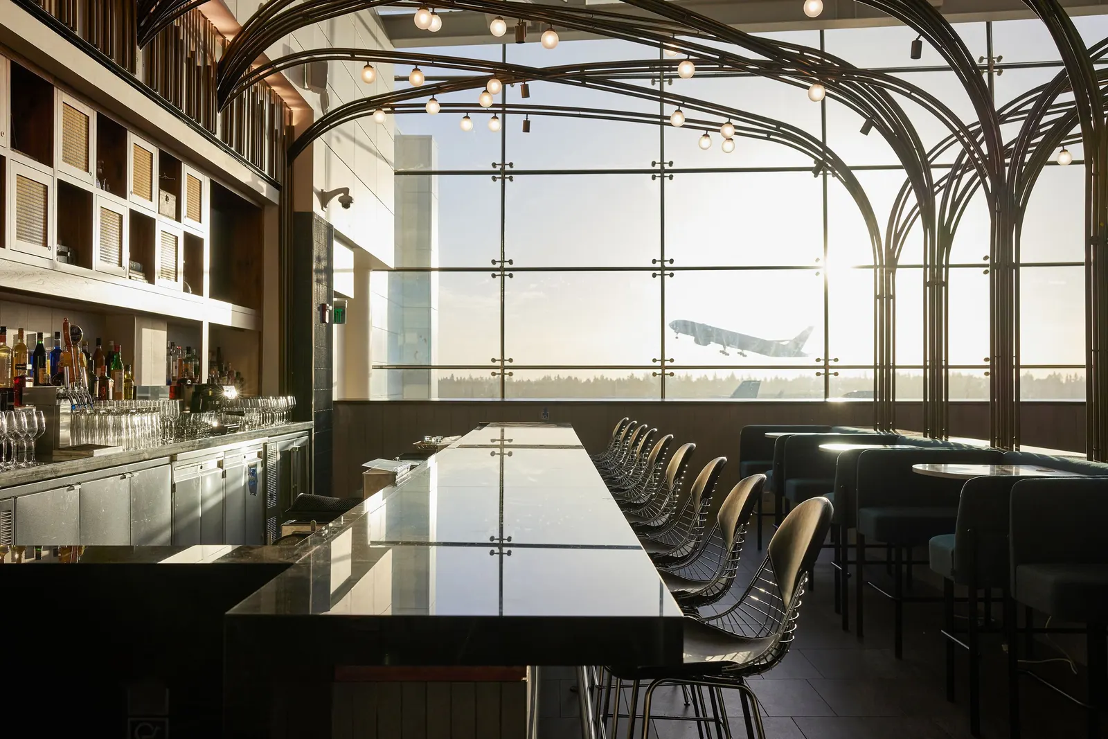 Bar with teal booths and Seattle-inspired design in the Centurion Lounge at Seattle-Tacoma International Airport (SEA).