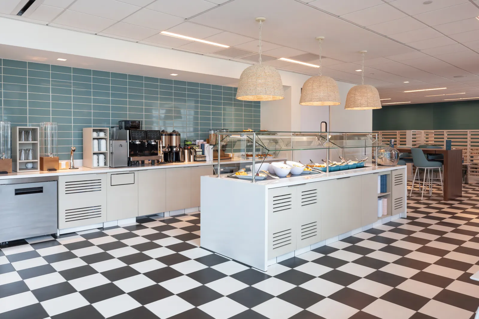 Buffet island and coffee station under woven pendants in the Escape Lounge at Luis Muñoz Marín International Airport (SJU).