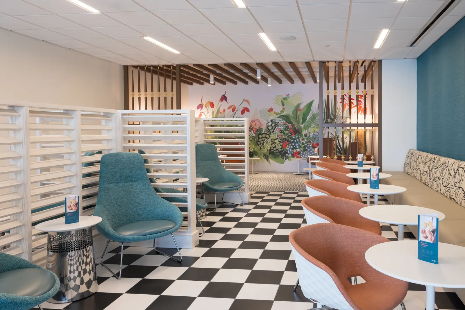 Mixed seating, privacy screens and tropical mural in the Escape Lounge at Luis Muñoz Marín International Airport (SJU).