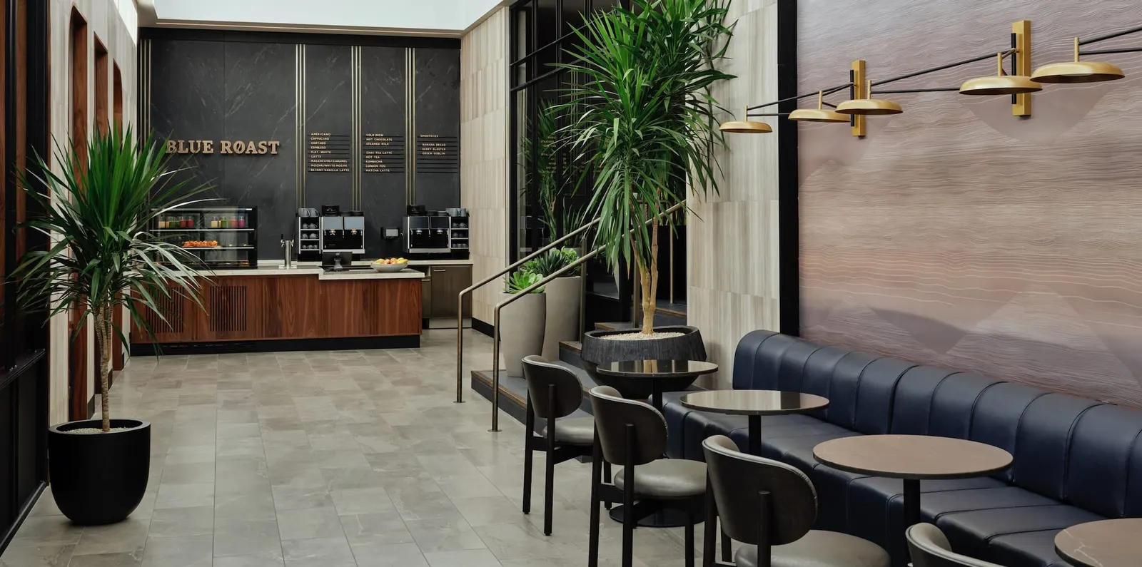 Blue Roast coffee bar with navy banquette and gold pendants in The Centurion Lounge at Salt Lake City (SLC).