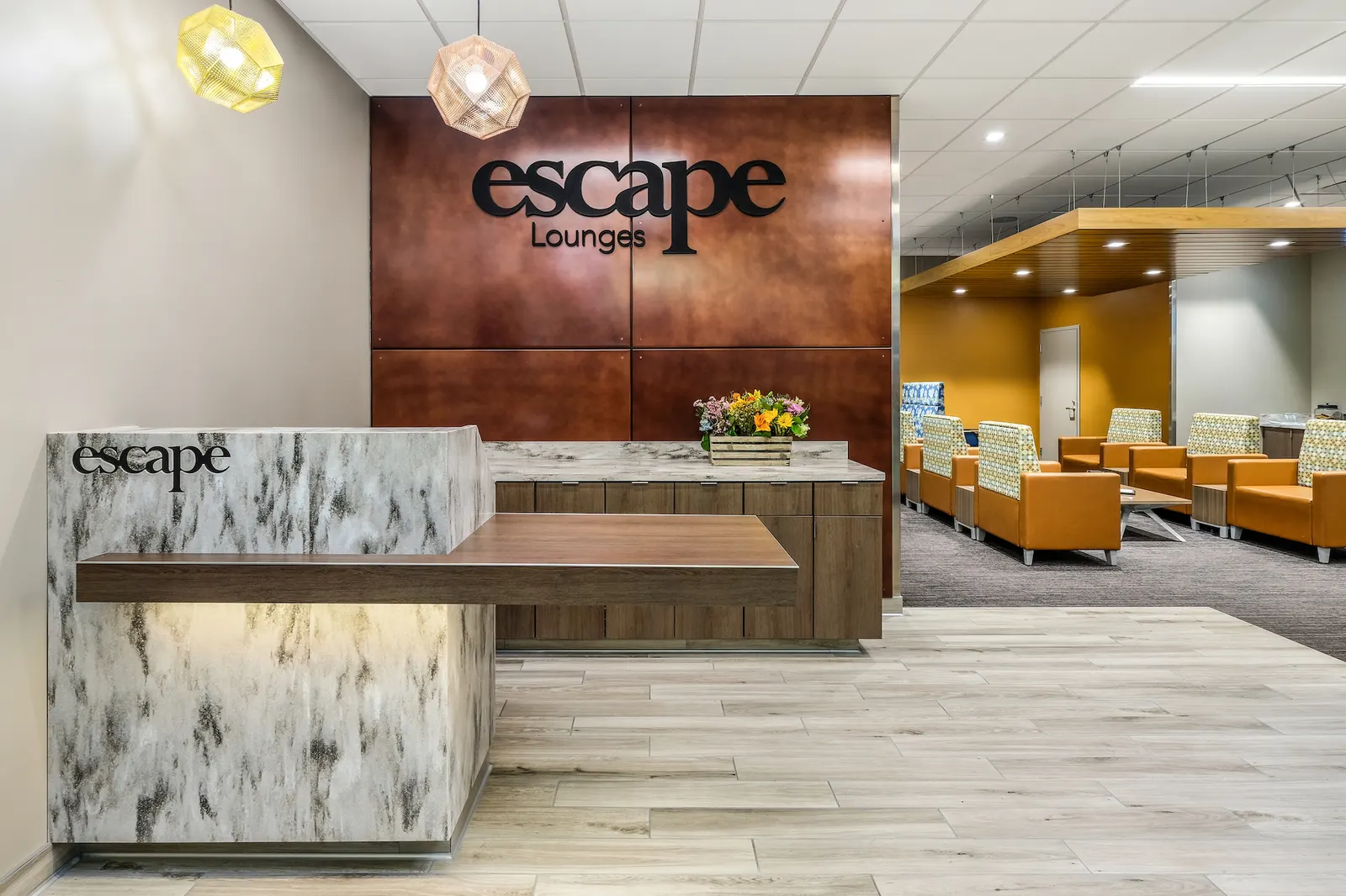 Marble reception desk and Escape Lounges logo wall in Terminal A at Sacramento International Airport (SMF).