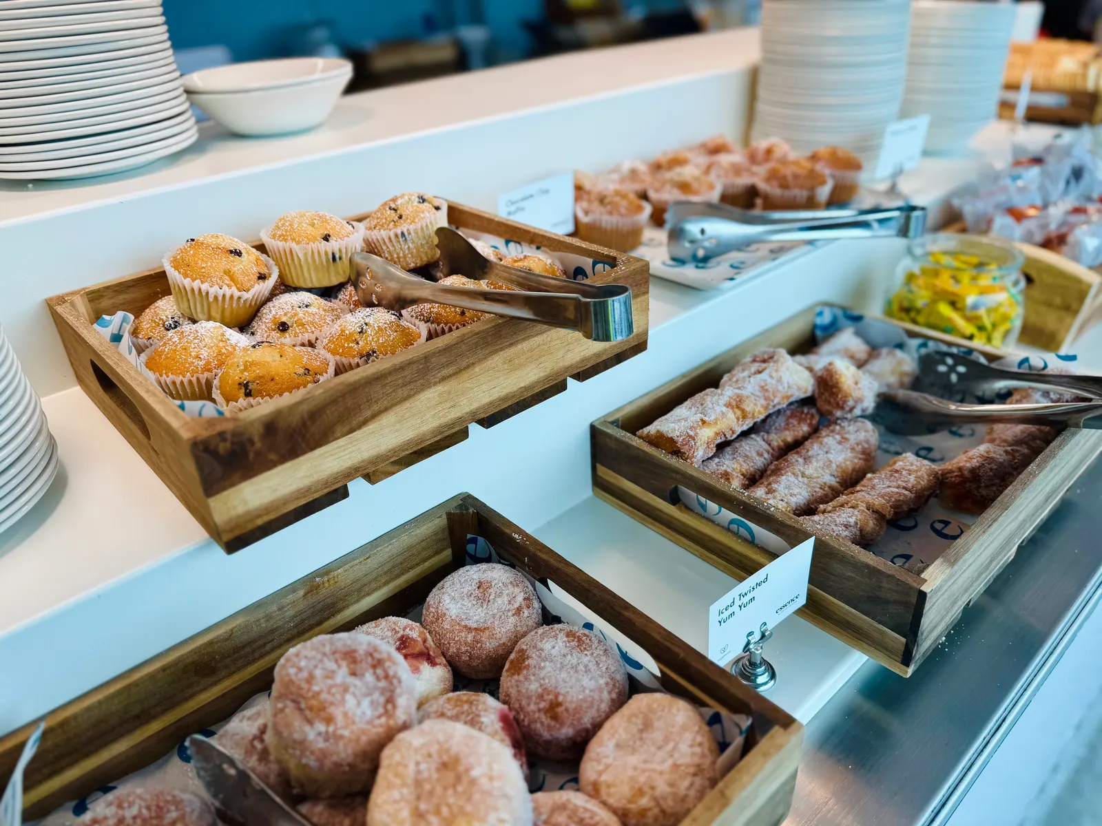 Pastry and muffin crates on the buffet in Essence by Escape Lounges at London Stansted Airport (STN).