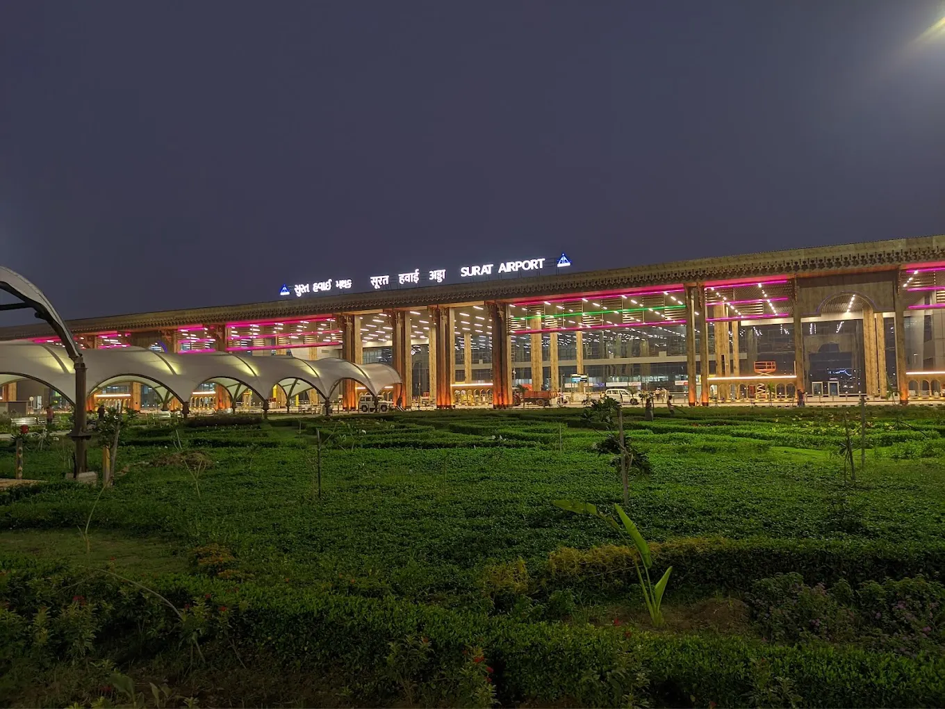 Surat Airport expanded landside façade at night, signed Surat Airport in Gujarati, Hindi and English